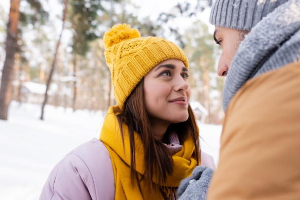 Mujer sonriente mirando al novio en el parque de invierno  - Foto, imagen