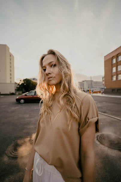 Lifestyle fashion portrait of young blonde hipster woman posing on the street, wearing trendy outfit. - Fotoğraf, Görsel