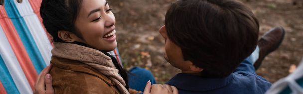 Mulher asiática sorrindo para namorado na rede ao ar livre, banner  - Foto, Imagem