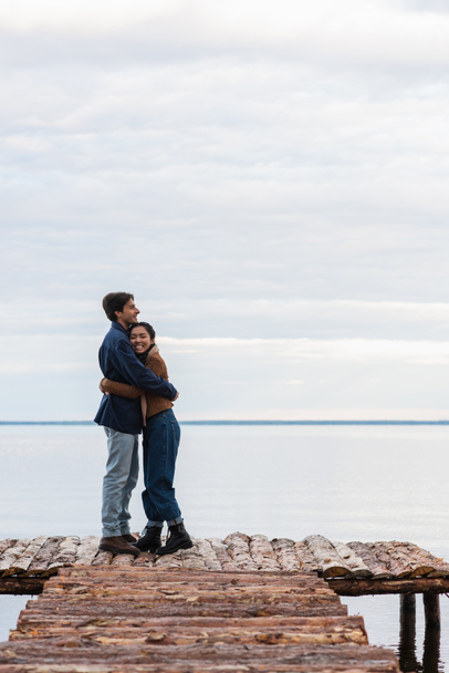 Happy asian woman hugging boyfriend on wooden pier  - Fotografie, Obrázek