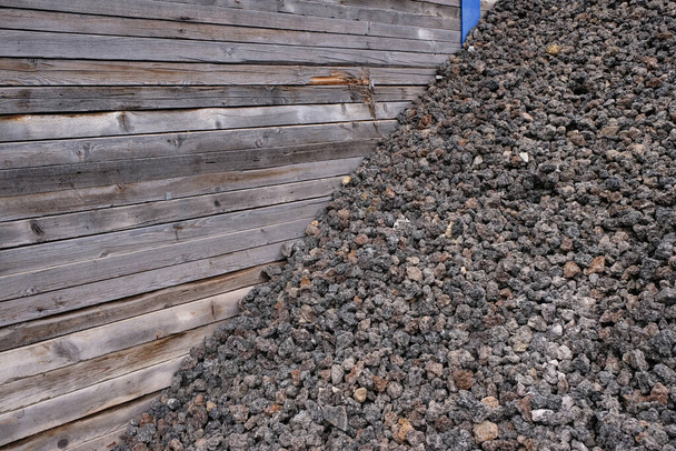 Pilha de pedras vulcânicas para venda em uma cerca de madeira. - Foto, Imagem