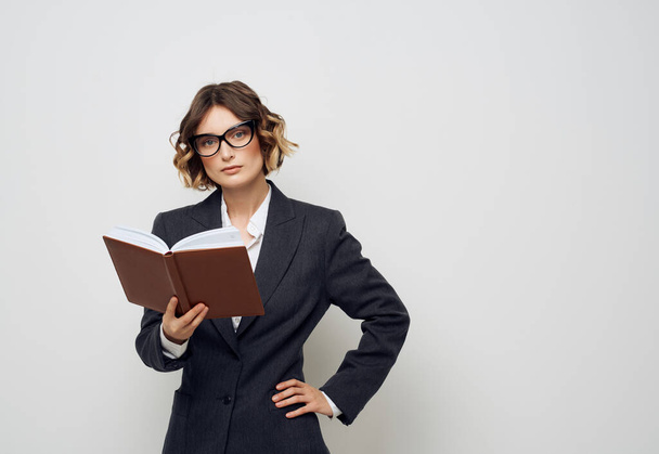 woman in business suit with a book in his hands isolated background - Photo, Image