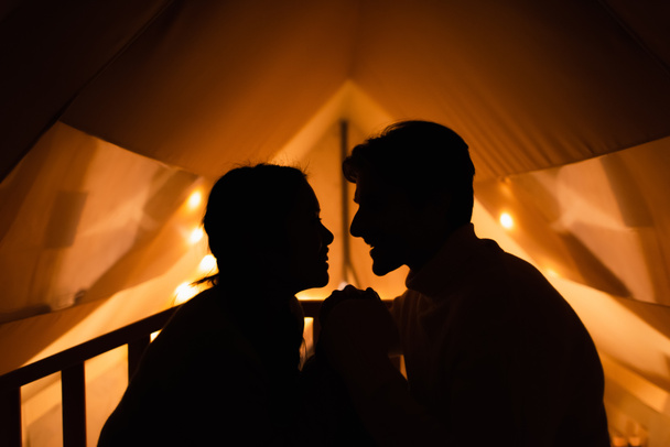 Vista laterale di silhouette di coppia in casa glamping  - Foto, immagini