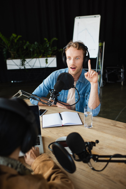 amazed radio host in headphones having idea during podcast - Foto, immagini