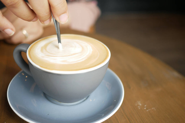 persona mano revolviendo café con cuchara. - Foto, Imagen