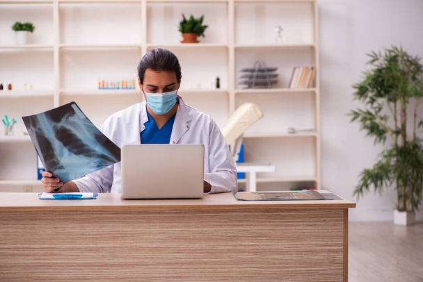 パンデミック時に顔マスクを着用する若い男性医師放射線科医 - 写真・画像