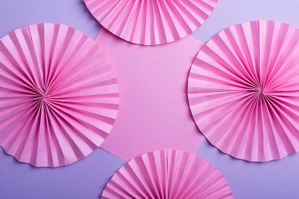 Розовые круги бумажные вентиляторы на фиолетовом фоне  - Фото, изображение