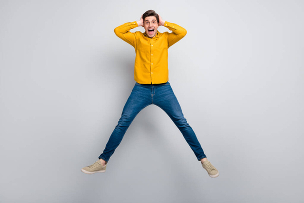 Full length body size view of attractive cheerful lucky man jumping having fun isolated over grey color background - Foto, Imagem