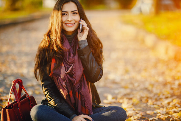 brunette girl using phone while at the park - Valokuva, kuva