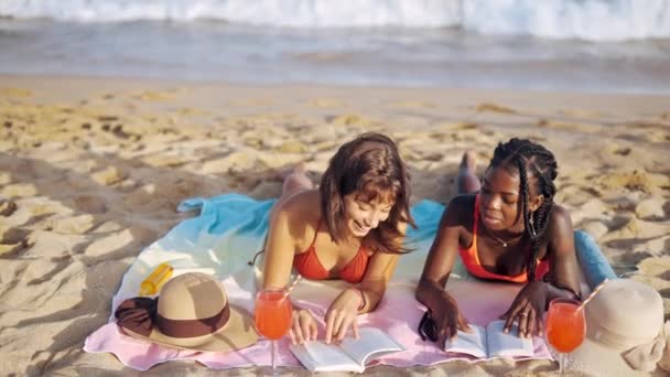Молодые женщины в купальниках лежат на песчаном берегу - Кадры, видео
