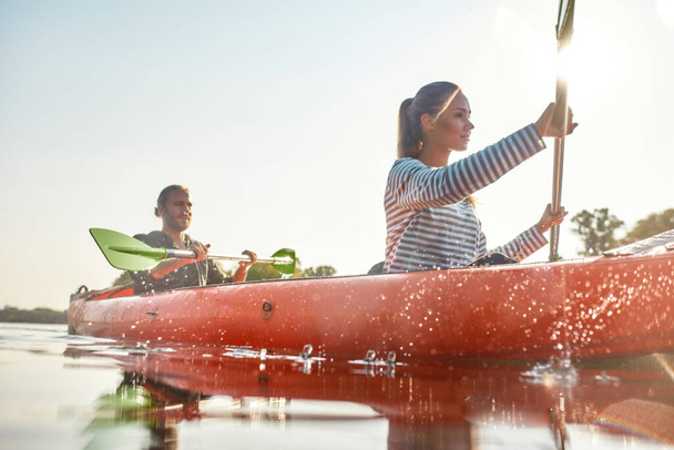 Young people kayaking together in a river on a summer day. Water splashes - 写真・画像