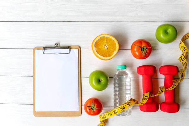 Planning for Diet Health eat and food.  Sport exercise equipment workout with fresh fruit, measuring tap, note pad for fitness style. Nutrition Healthy Lifestyle Concept, Top view and copy space - Fotoğraf, Görsel