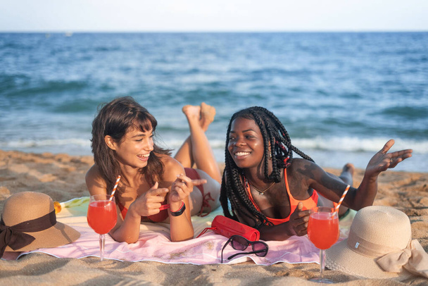 Happy diverse girlfriends chilling on beach - 写真・画像