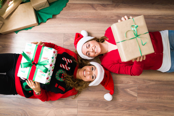 Wymiana prezentów świątecznych. Portret pary LGBTQ pokazujący ich piękne prezenty  - Zdjęcie, obraz