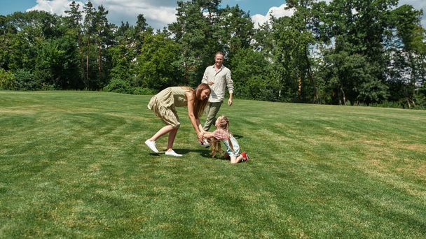 Família feliz se divertindo, jogando futebol no campo de grama no parque em um dia de verão - Foto, Imagem