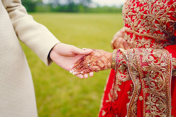 hindu bride walks behind husband holding garb - Foto, immagini