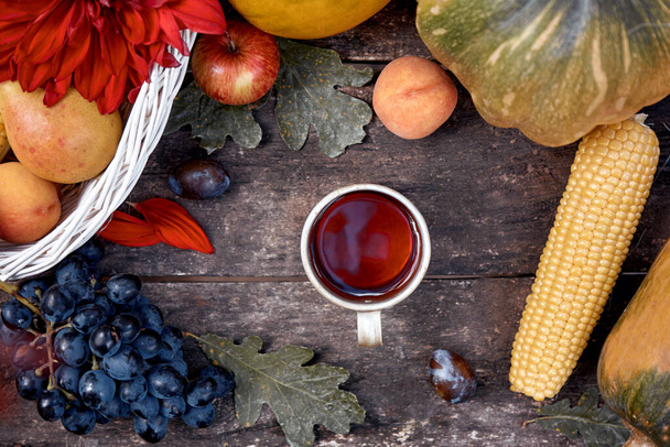 Podzimní estetická zátiší: ovoce, zelenina a šálek čaje: dýně, hrušky, jablka, meloun, hrozny a kukuřice. Koncept Dne díkůvzdání. Podzimní útulnost, pohled shora. Kvalitní fotografie - Fotografie, Obrázek