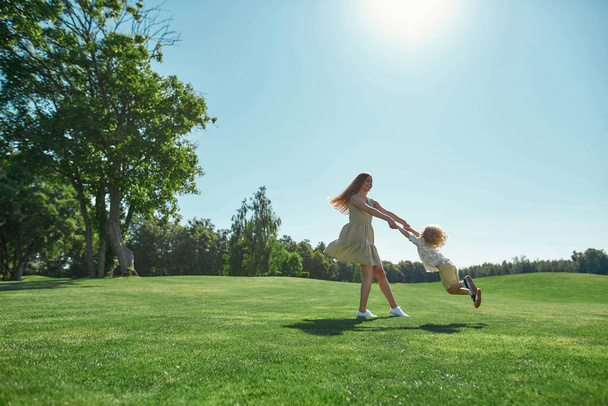 Happy little boy and her mother playing together in summer garden - Foto, imagen