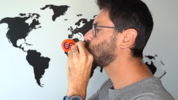 Un homme fait exploser un ballon avec un symbole dollar et une carte du monde en arrière-plan. inflation économique augmentation stagflation concept - Séquence, vidéo