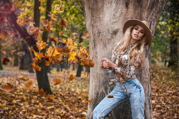 Schöne Herbst-Frau mit Herbstblättern auf Herbst Natur Hintergrund. Herbstmode. - Foto, Bild
