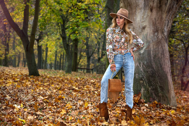 Hermosa mujer de otoño con hojas de otoño en el fondo de la naturaleza de otoño. Moda de otoño. - Foto, imagen
