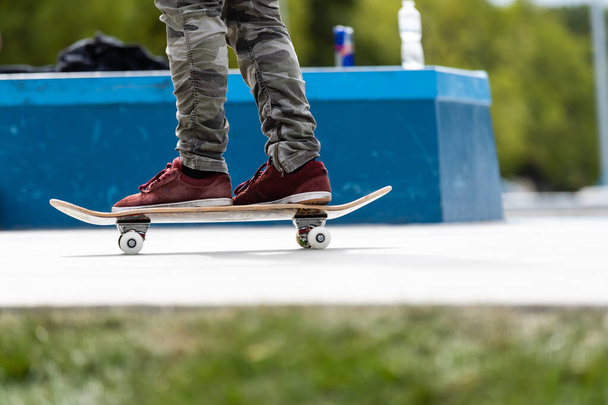 Primo piano dei piedi di uno skateboarder mentre pattina sul cemento allo skate park
 - Foto, immagini