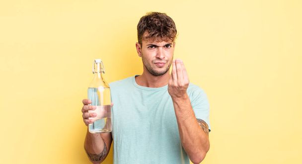 young handsome man making capice or money gesture, telling you to pay. water concept - Фото, изображение