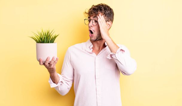young handsome man feeling happy, excited and surprised. decorative plant concept - Photo, Image