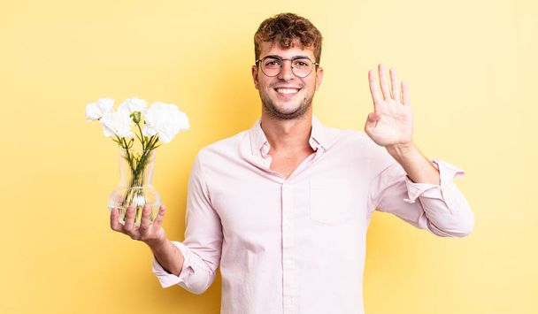 young handsome man smiling and looking friendly, showing number four. flowers concept - Foto, Bild