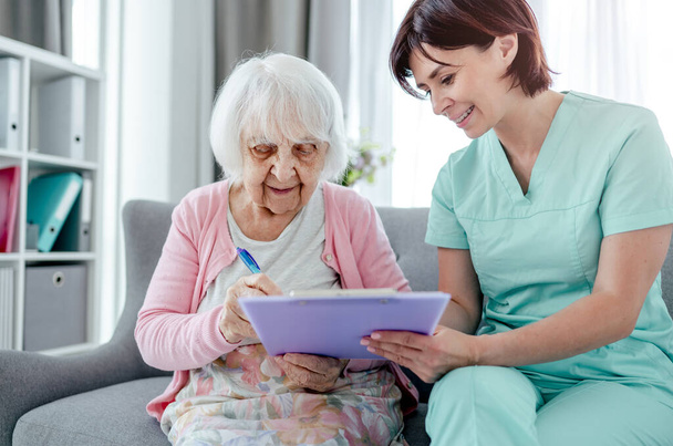 Elderly woman and nurse - Foto, afbeelding