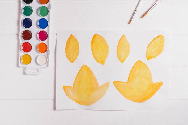 Krok po kroku samouczek jesienny papier wieniec. Krok 1: Malować jesienne liście o różnych kształtach, rozmiarach i kolorach akwarelami. Widok z góry - Zdjęcie, obraz