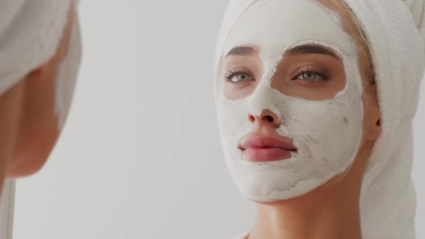 Nuori kaunis nainen, jolla on sovellettu Clay Mask kasvot peili - Materiaali, video