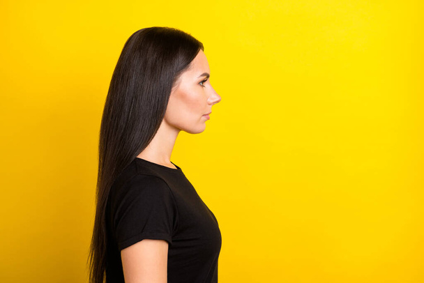 Profile photo of calm serious focused lady look empty space wear black t-shirt isolated yellow color background - Fotó, kép