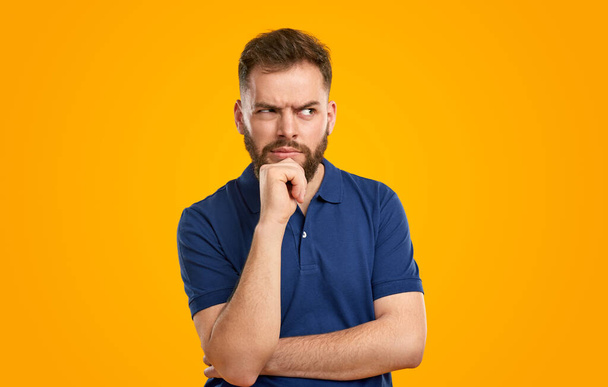 Pensive bearded man with hand at chin - Фото, зображення