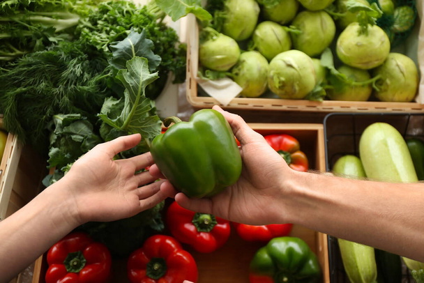 Jong stel kiest groenten op de markt - Foto, afbeelding