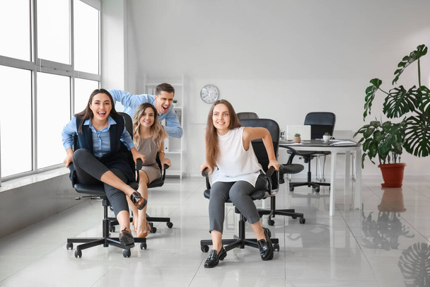 Felices colegas montando sillas en la oficina - Foto, imagen