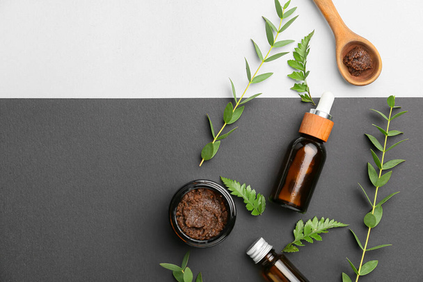 Bottles of healthy essential oil with scrub on dark background - Фото, изображение