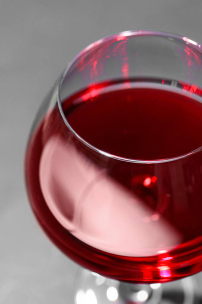 Ποτήρι κόκκινο κρασί σε γκρι φόντο, closeup - Φωτογραφία, εικόνα