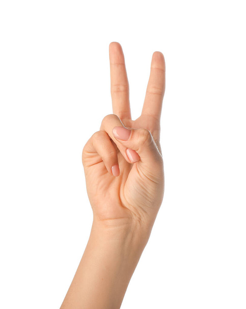 Woman showing victory gesture on white background - Fotoğraf, Görsel