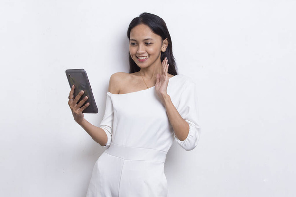 счастливая молодая азиатская красивая женщина с помощью мобильного телефона изолированы на белом фоне - Фото, изображение