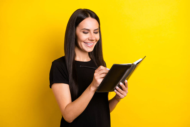Photo of pretty satisfied person toothy smile hands hold notebook pencil isolated on yellow color background - Fotó, kép