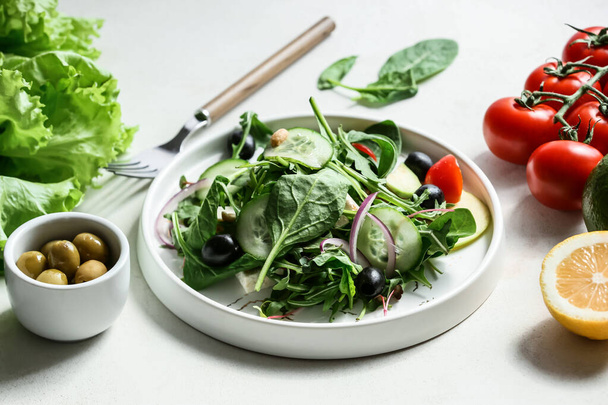 Plate with tasty healthy salad on table in kitchen - Photo, Image