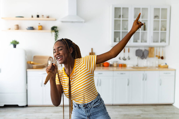 Jovem mulher negra se divertindo enquanto cozinha na cozinha - Foto, Imagem