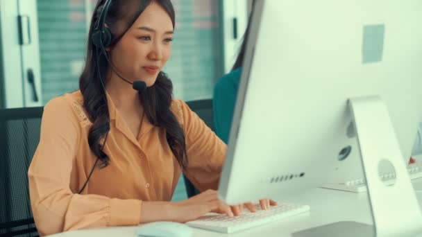 Bizneswoman w słuchawkach pracuje aktywnie w biurze - Materiał filmowy, wideo
