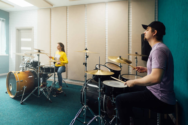 A girl and a guy playing drums. Music group rehearsal. - Photo, Image