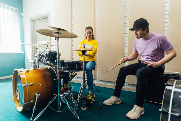 Music teacher explaining woman to play drum bass. - Valokuva, kuva