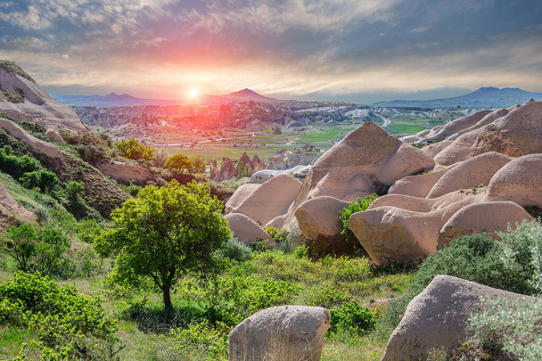 Beautiful sunset over the pyramidal tuff mountains in the Red Valley in Cappadocia. Turkey - Foto, afbeelding
