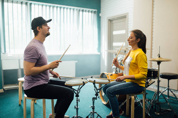 A guy instructor and a girl play rhythm practice pads opposite each other. Music lesson with teacher. - Valokuva, kuva