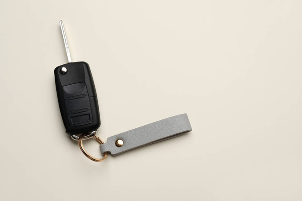 Κλειδί αυτοκινήτου με δερμάτινο μπρελόκ στο φως φόντο - Φωτογραφία, εικόνα