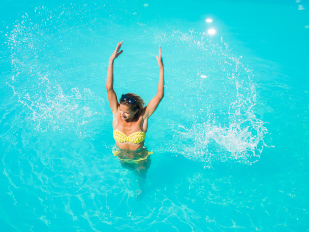 A girl is relaxing in a swimming pool - Foto, afbeelding